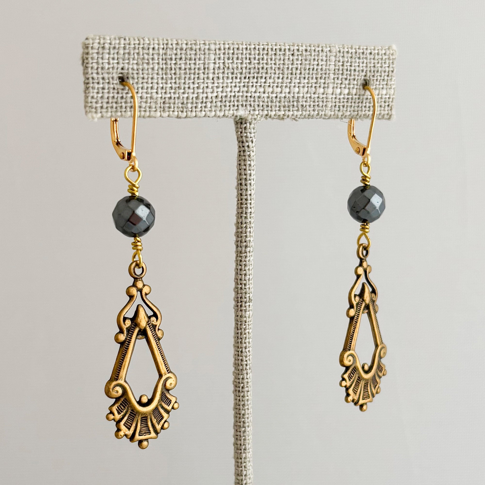 Art Nouveau oxidized brass-tone and hematite beaded earrings on a linen t bar 