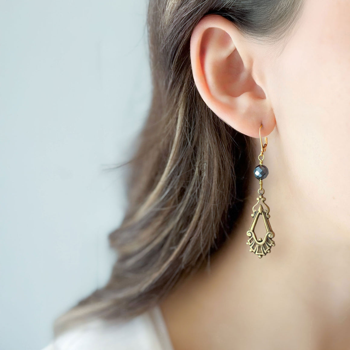 Art Nouveau oxidized brass-tone and hematite beaded earrings on a linen t bar 