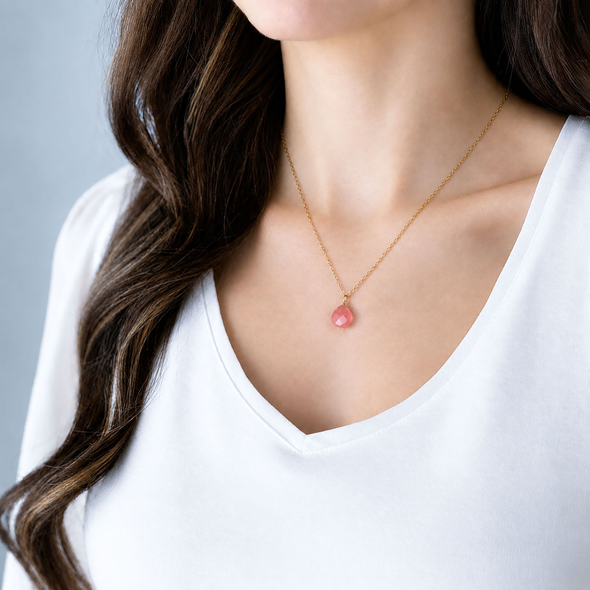 Woman wearing a faceted cherry quartz pendant necklace on a 14K gold-filled chain