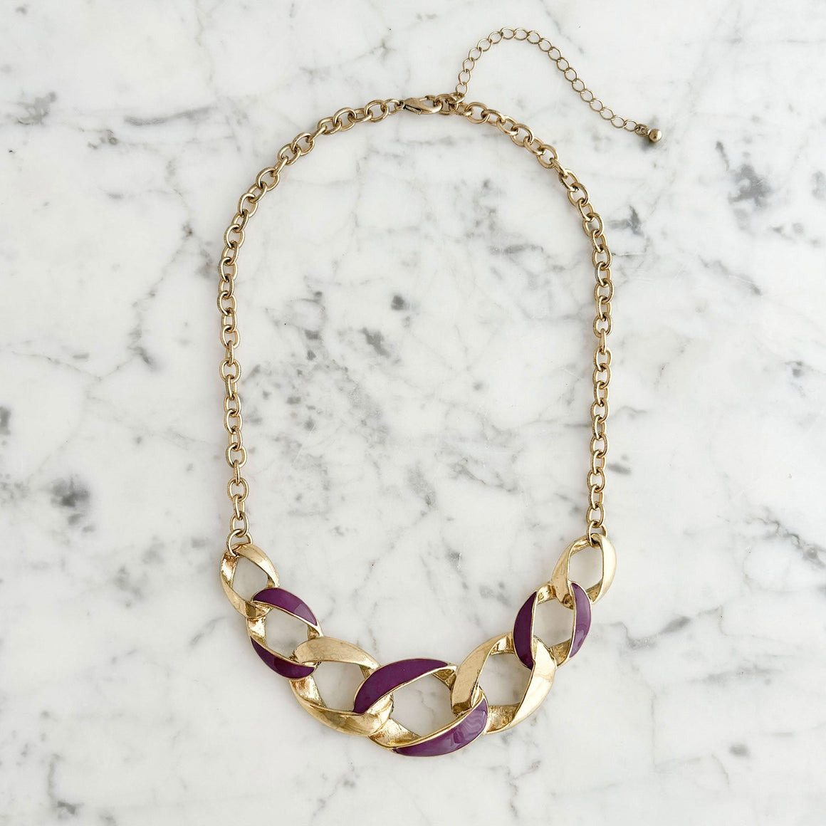 Vintage gold tone curb chain necklace with purple enamel detailing worn by a model