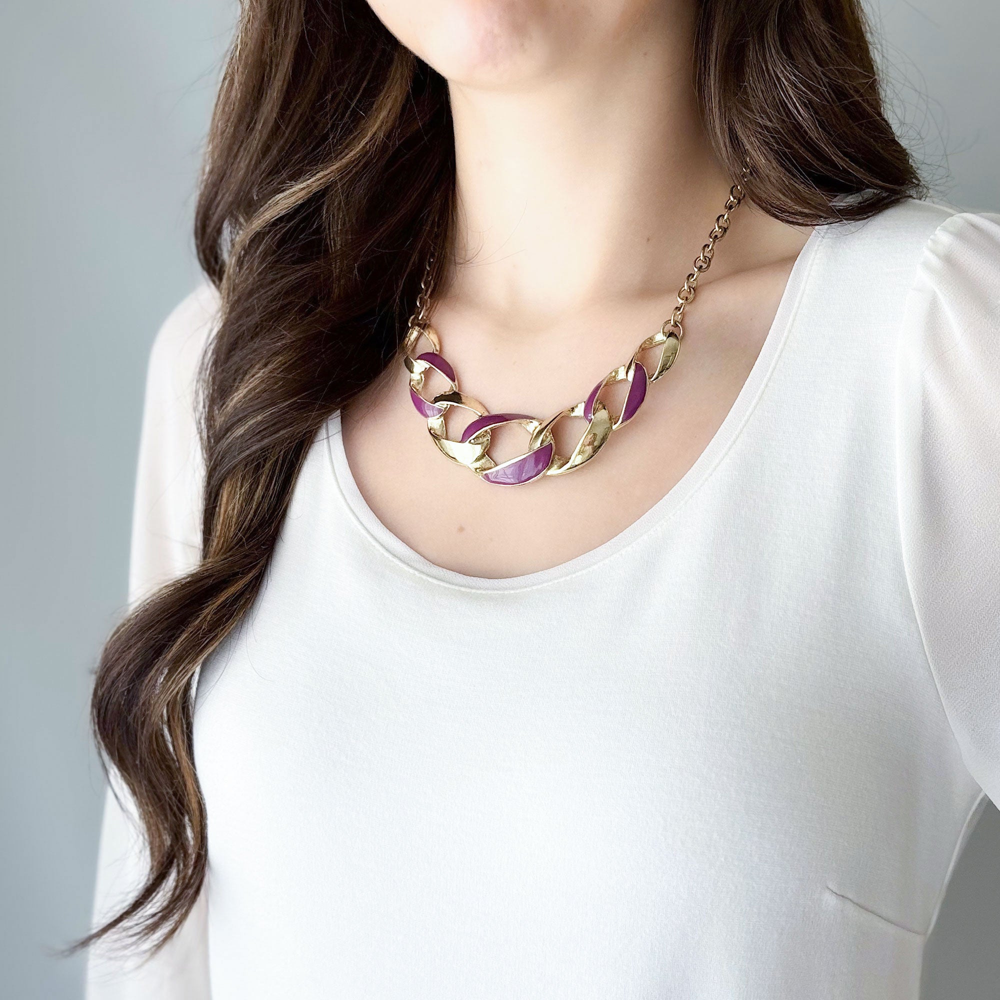 Vintage gold tone curb chain necklace with purple enamel detailing worn by a model