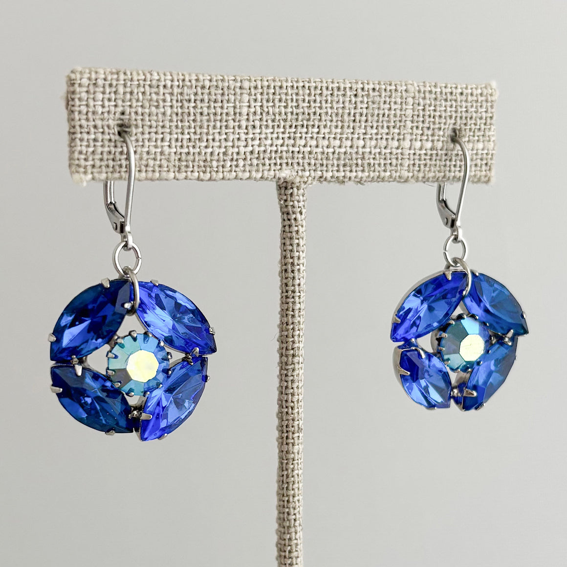 Sapphire blue crystal drop earring with iridescent accents worn by a model with dark hair