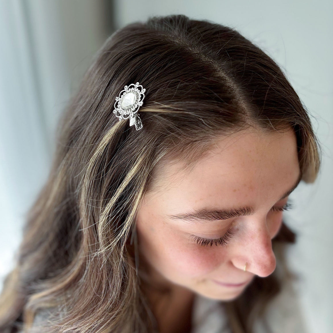 Silver floral hair clip with faceted crystal centre shown in with gem colour options