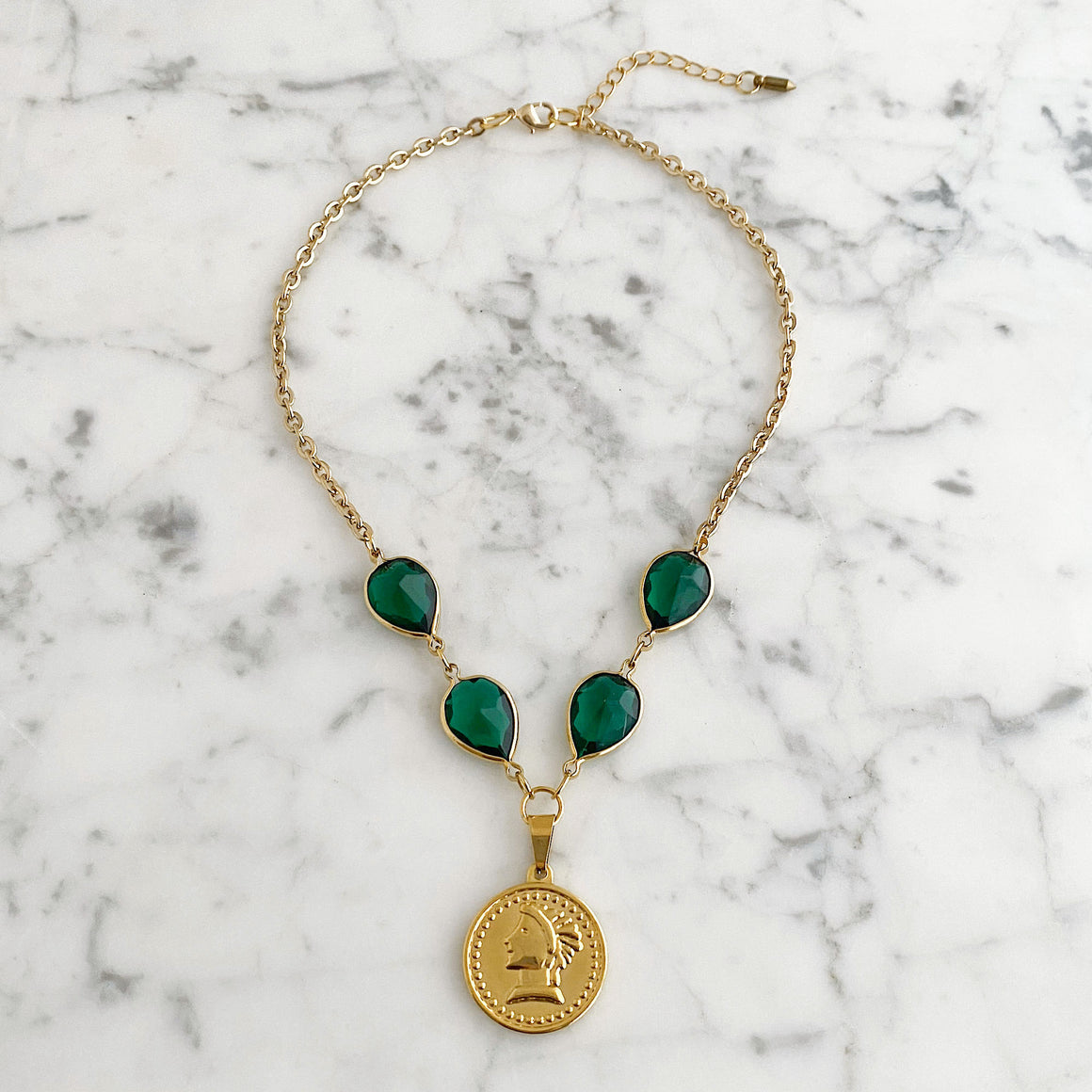 Vintage green crystal necklace with gold-tone coin pendant worn on a model