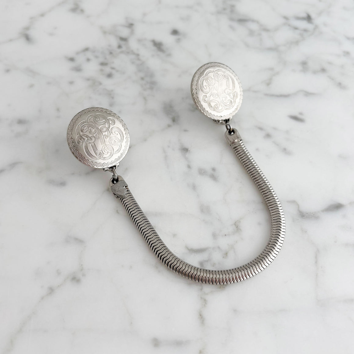 Vintage silver-tone sweater clips worn on a fur shawl